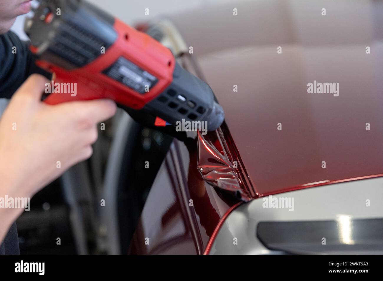 Wrapping a new foil to a car by heat gun, gluing a new foil, detailing
