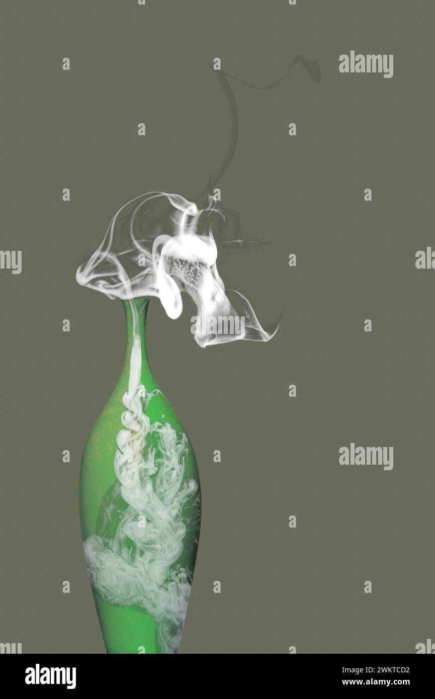 Green glass vase with smoke against the oliv green background Stock Photo
