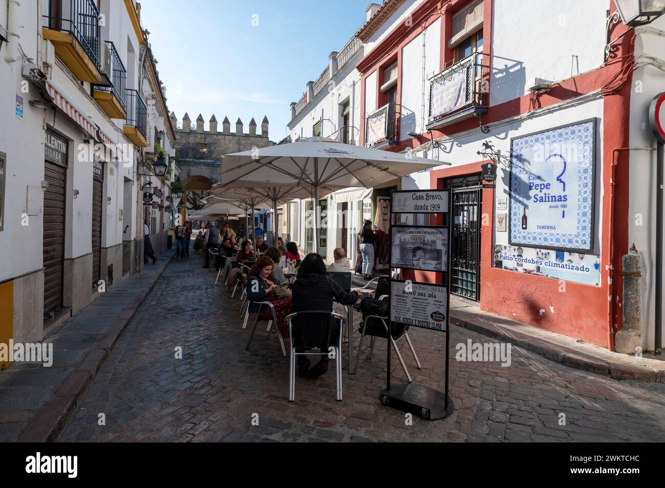 An outdoor restaurant scene near the Puerta de Almodovar (Almodovar gate) in the old Jewish quarter of the historic city of Cordoba in Andalusia, south Stock Photo