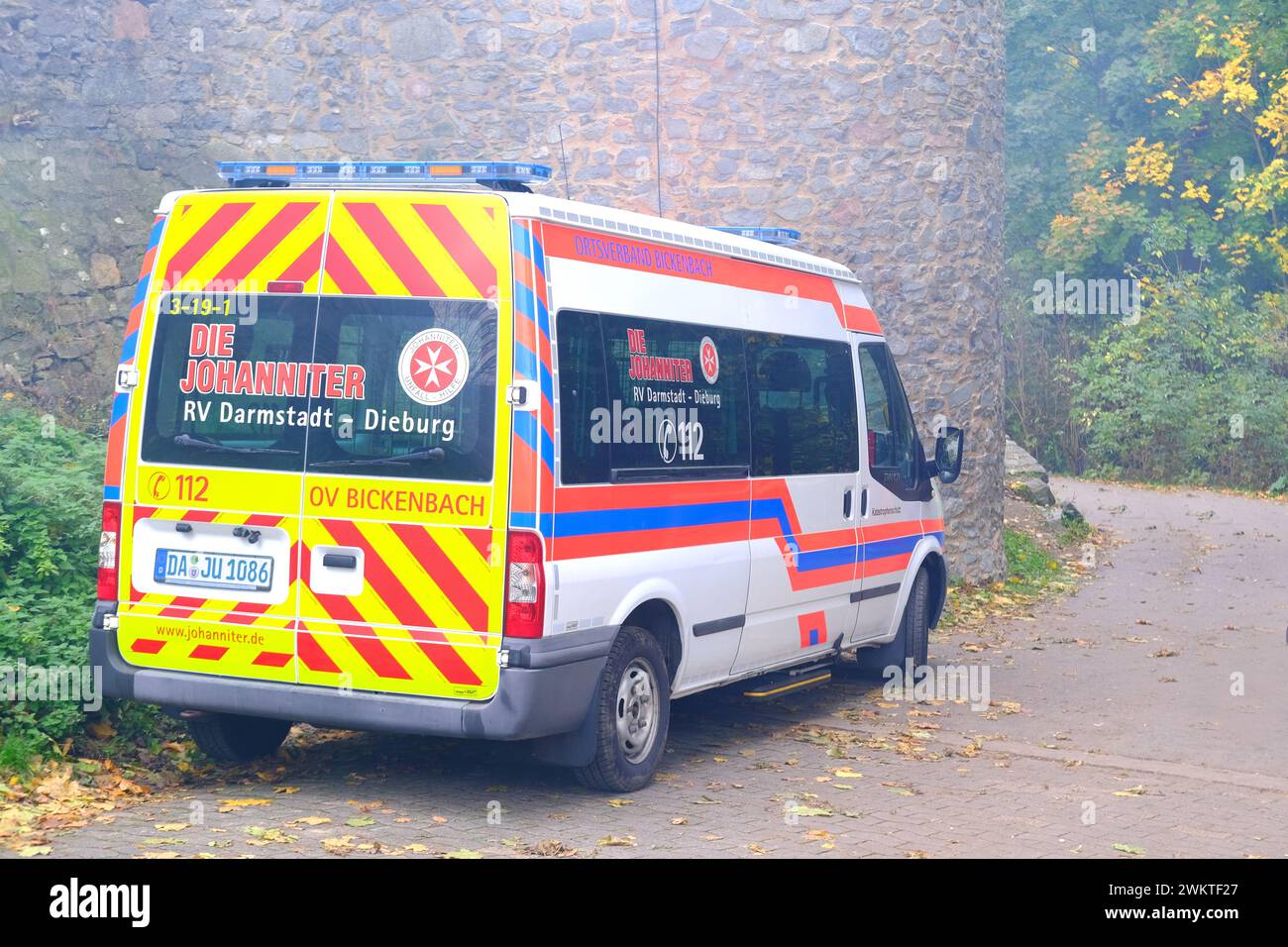 ambulance parked by ancient wall in city, concept providing urgent medical assistance, German medical services, Rapid Response Vehicles, intensive car Stock Photo
