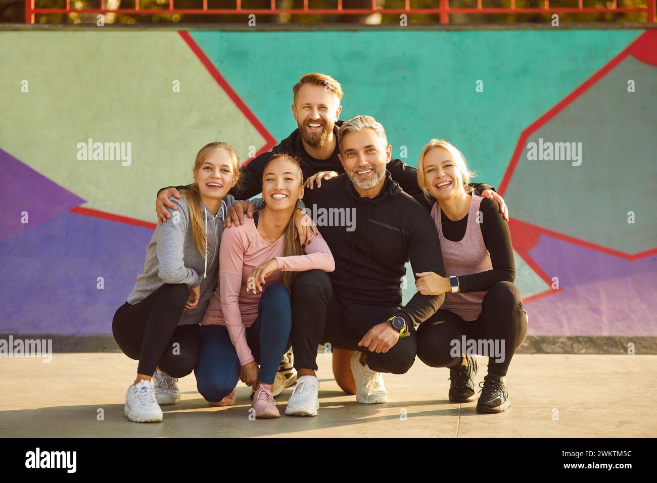 Group of happy smiling people in sportswear looking at camera after sport workout outdoors. Stock Photo