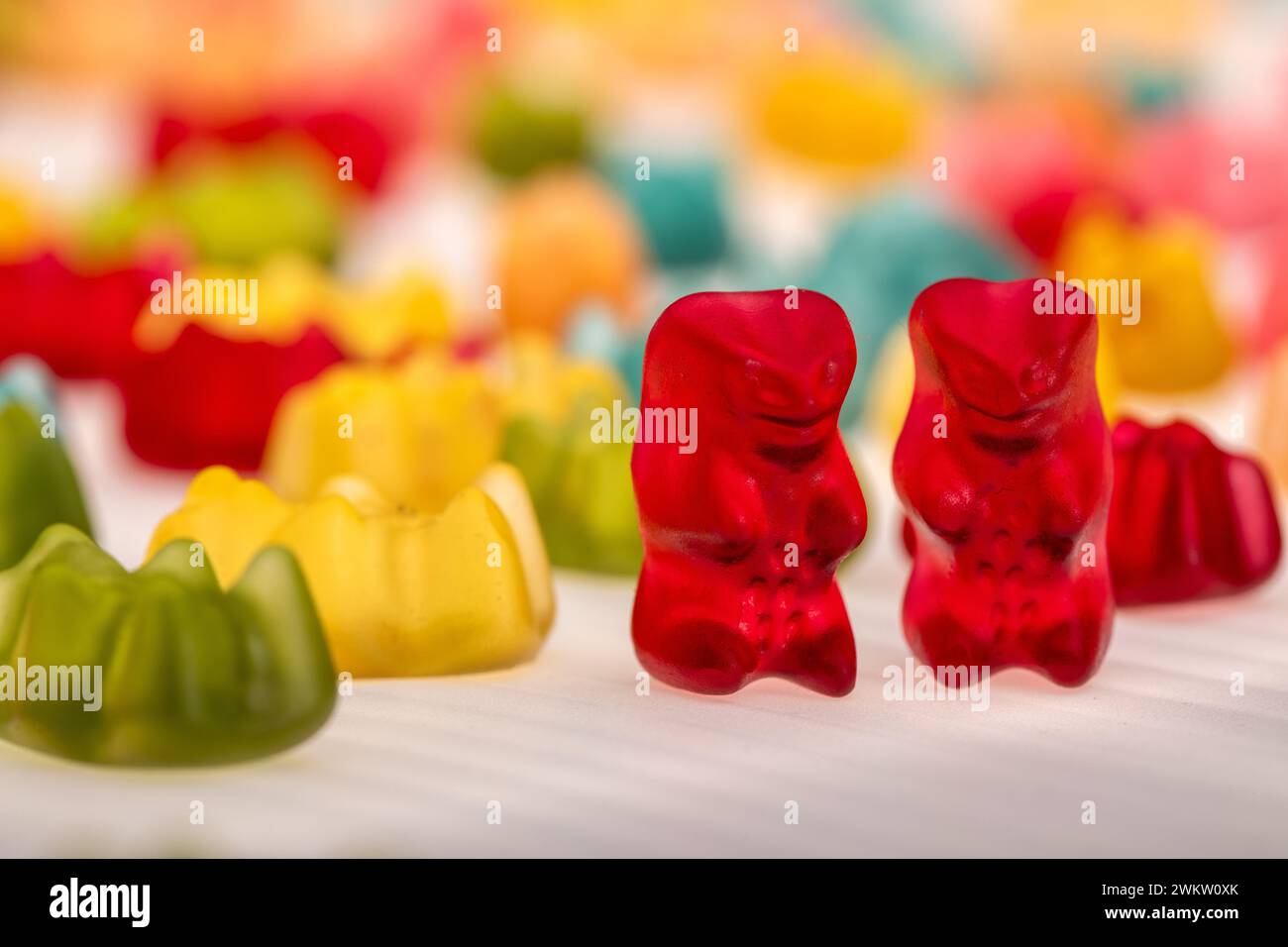 Sweet Friendship: Two Red Gummy Bears Bonding on Colorful Background, Friendship Talk Stock Photo