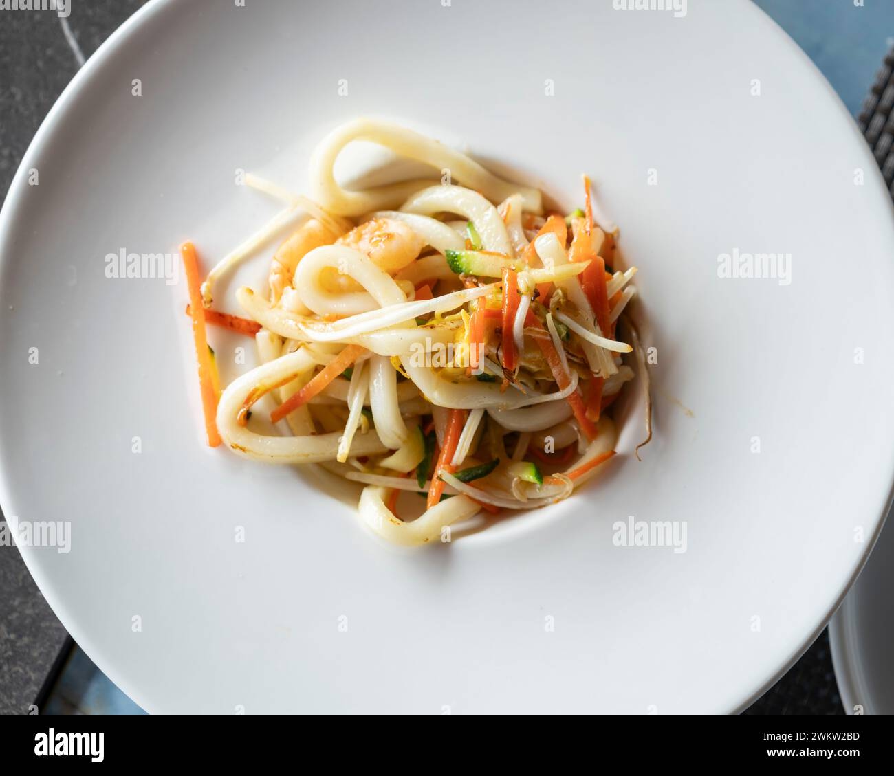 Stir-fried Yaki Udon noodles with shrimps fish, vegetables and soy-based Sauce. Japanese food. Top view Stock Photo