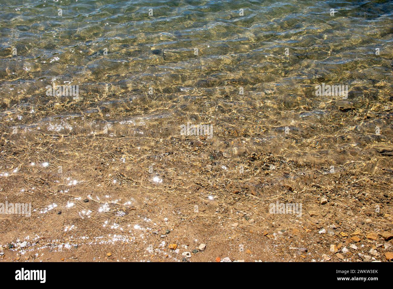 Sun rays reflecting star effect in water surface at Lokvarsko Lake, Croatia Stock Photo
