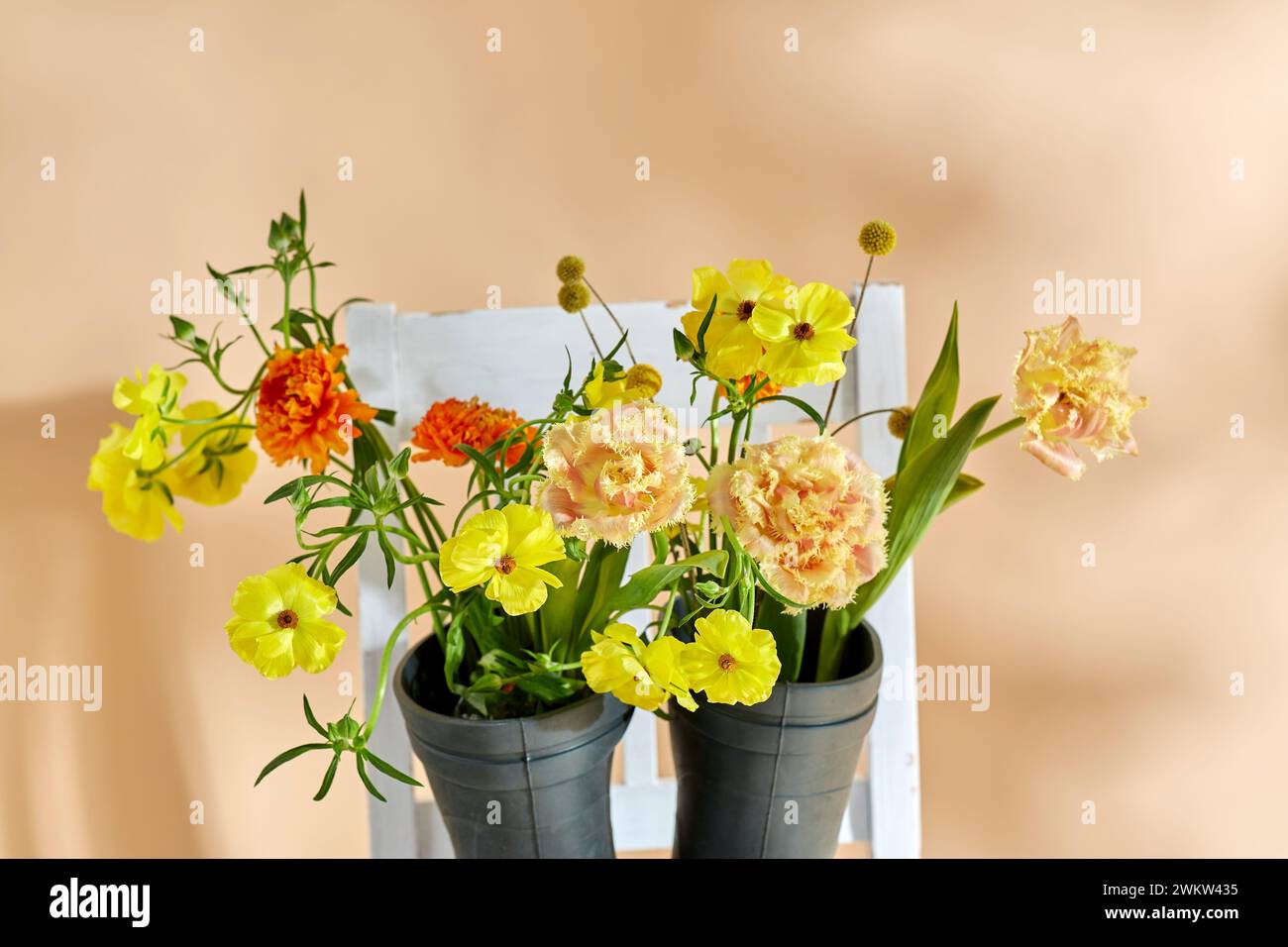 flowers in rubber boots on vintage chair Stock Photo - Alamy