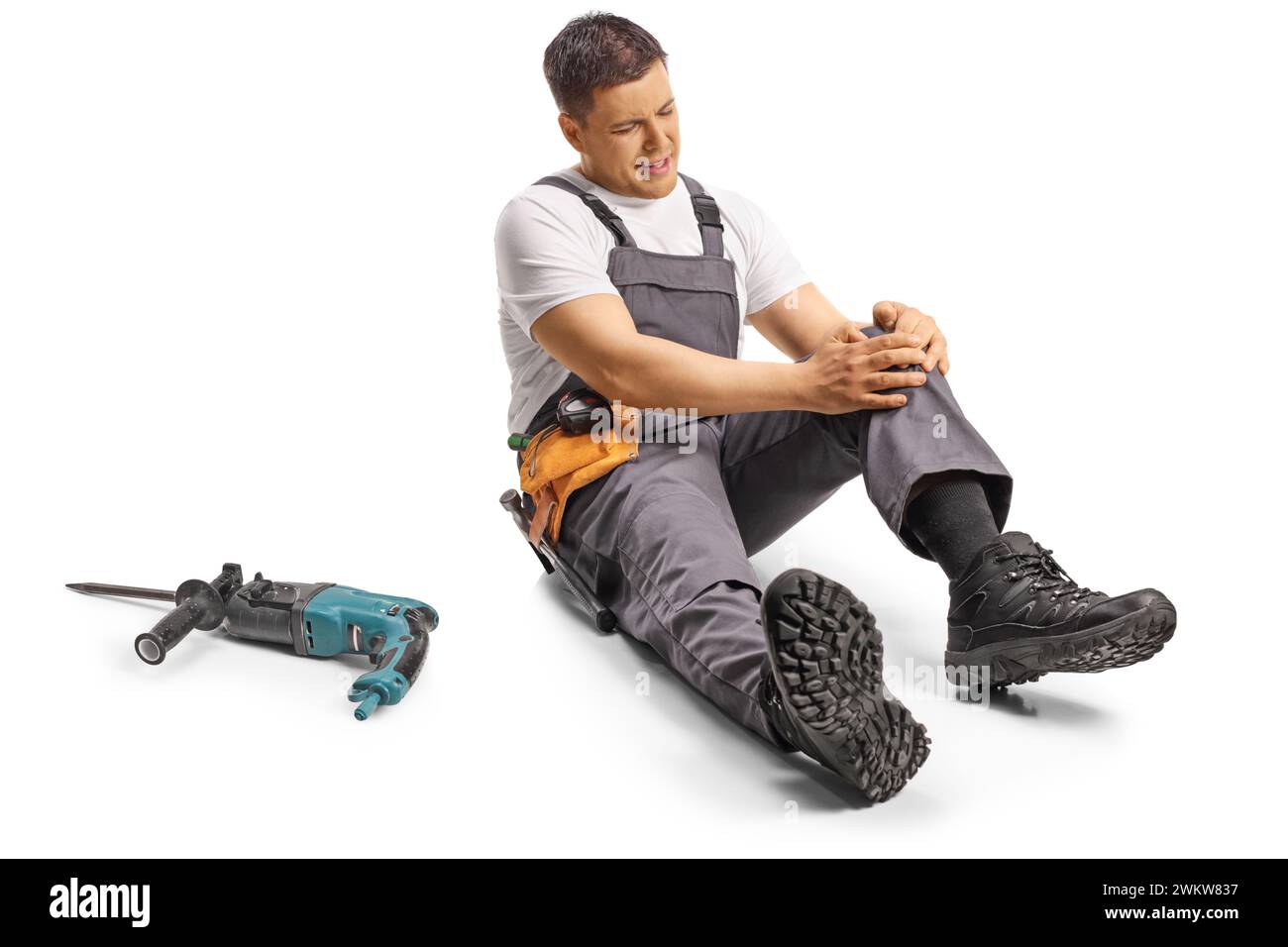 Repairman with knee injury sitting on the ground isolated on white ...