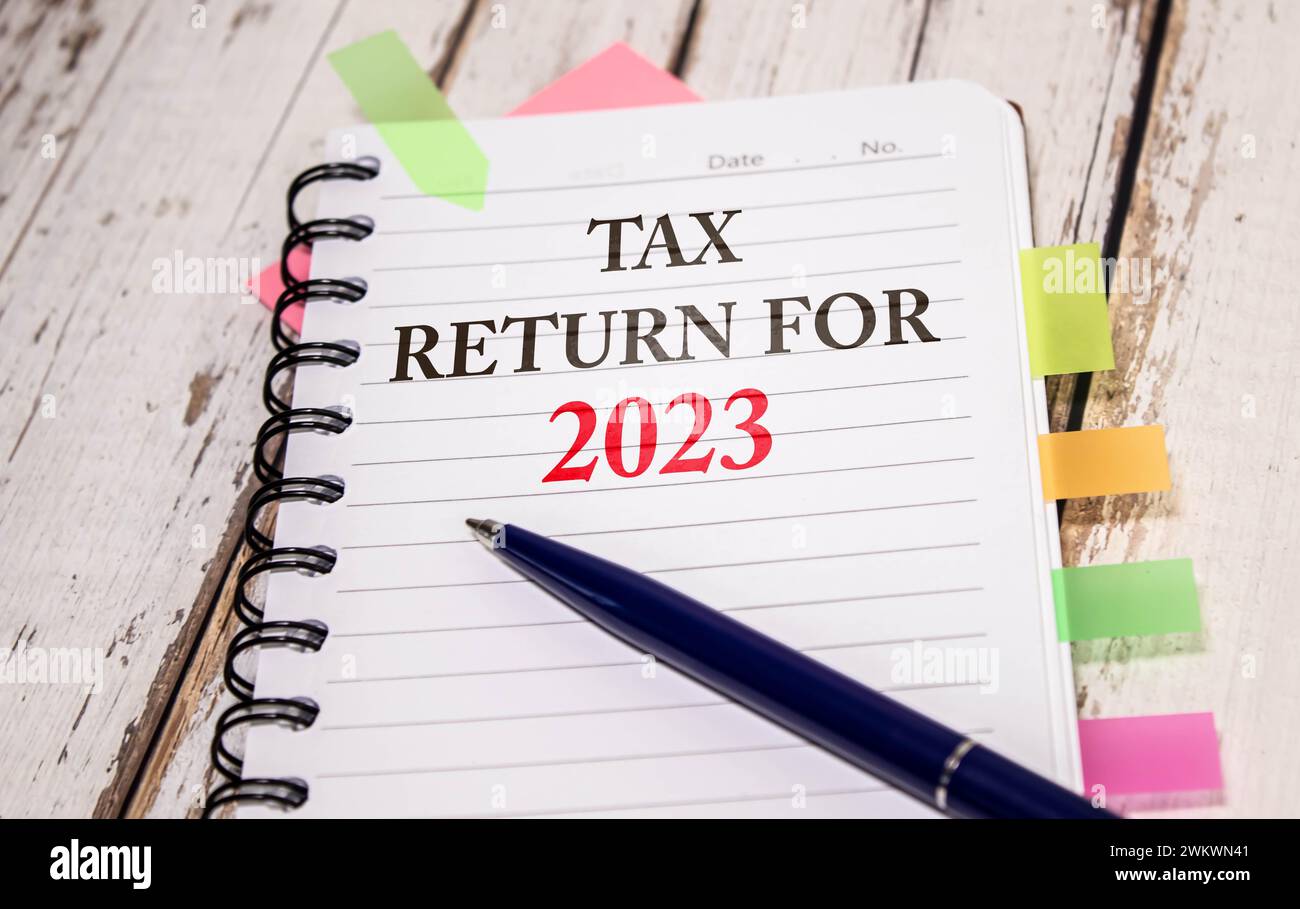Tax text in wooden cubes and tax or vat form documents to complete Individual income tax return form for payment to Government. Calculation tax return Stock Photo