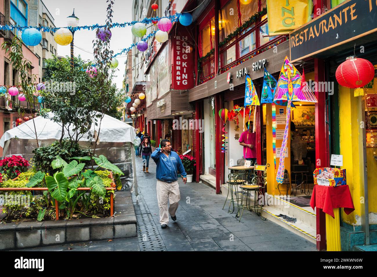 Pedestrians walk past restaurant and store facades in Chinatown in central Mexico City, Mexico. Stock Photo