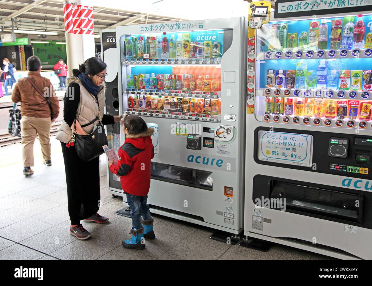 People at a drinks vending machine at a station platform in Tokyo, Japan. Stock Photo