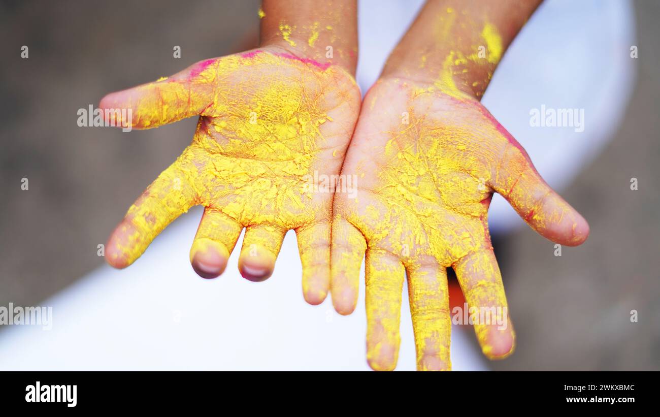 Happy Cute Smiling little Indian kids showing their colourful hands or palm printing or playing holi festival with colours Stock Photo