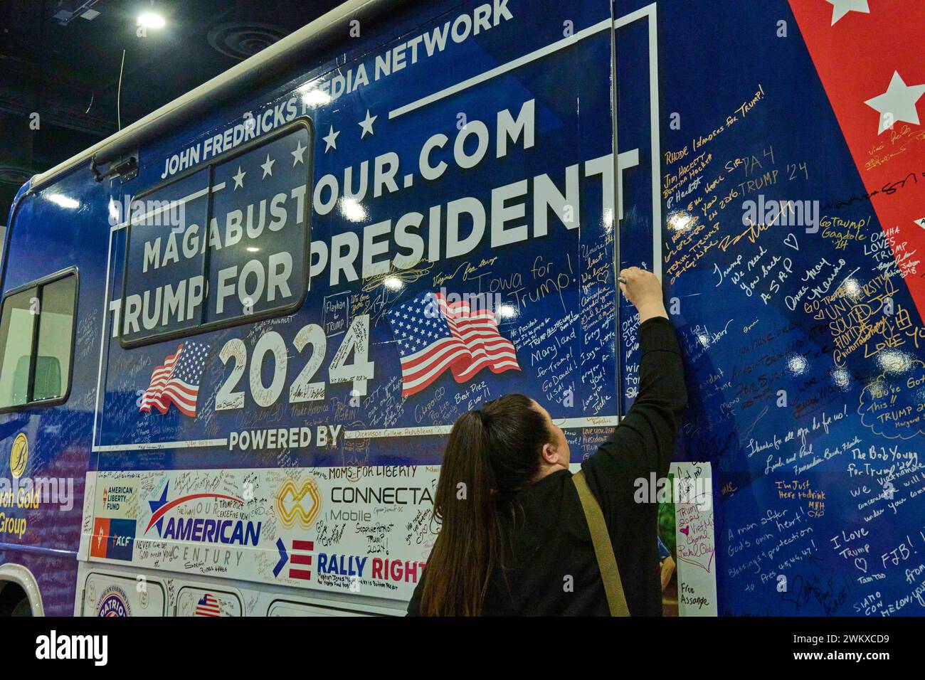 National Harbor, Maryland, USA. 22nd Feb, 2024. A woman signs a MAGA ...