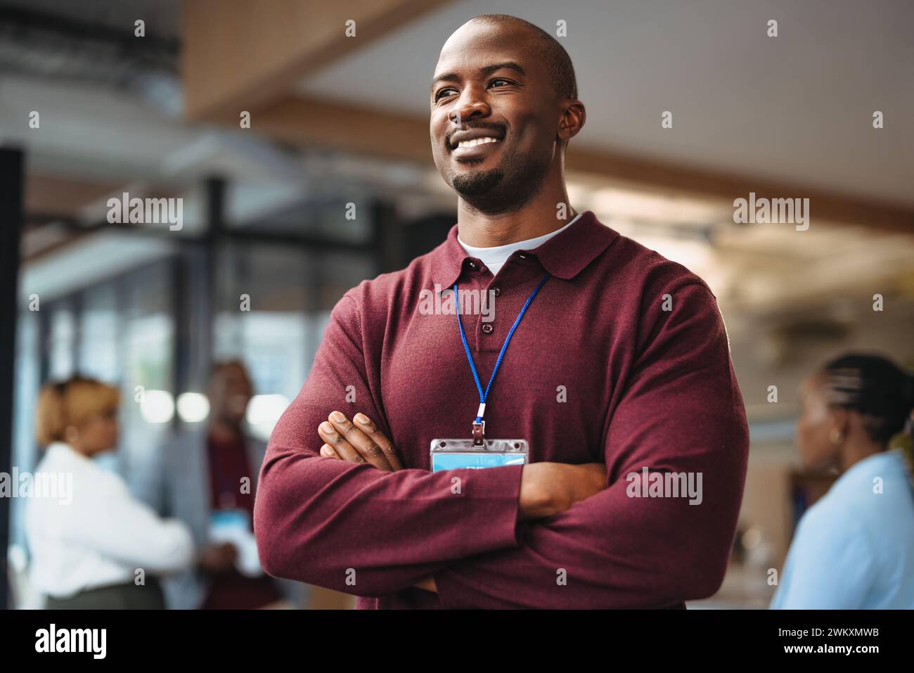 Business man stands confidently with arms crossed, wearing a badge. His ...
