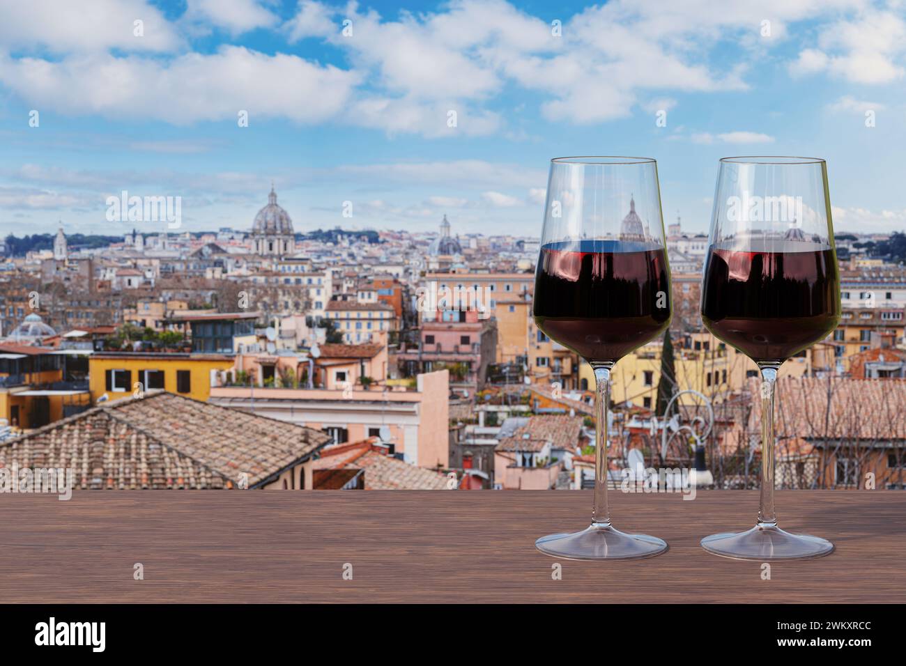 Two glasses of red wine on the table against view of Rome with a blue ...