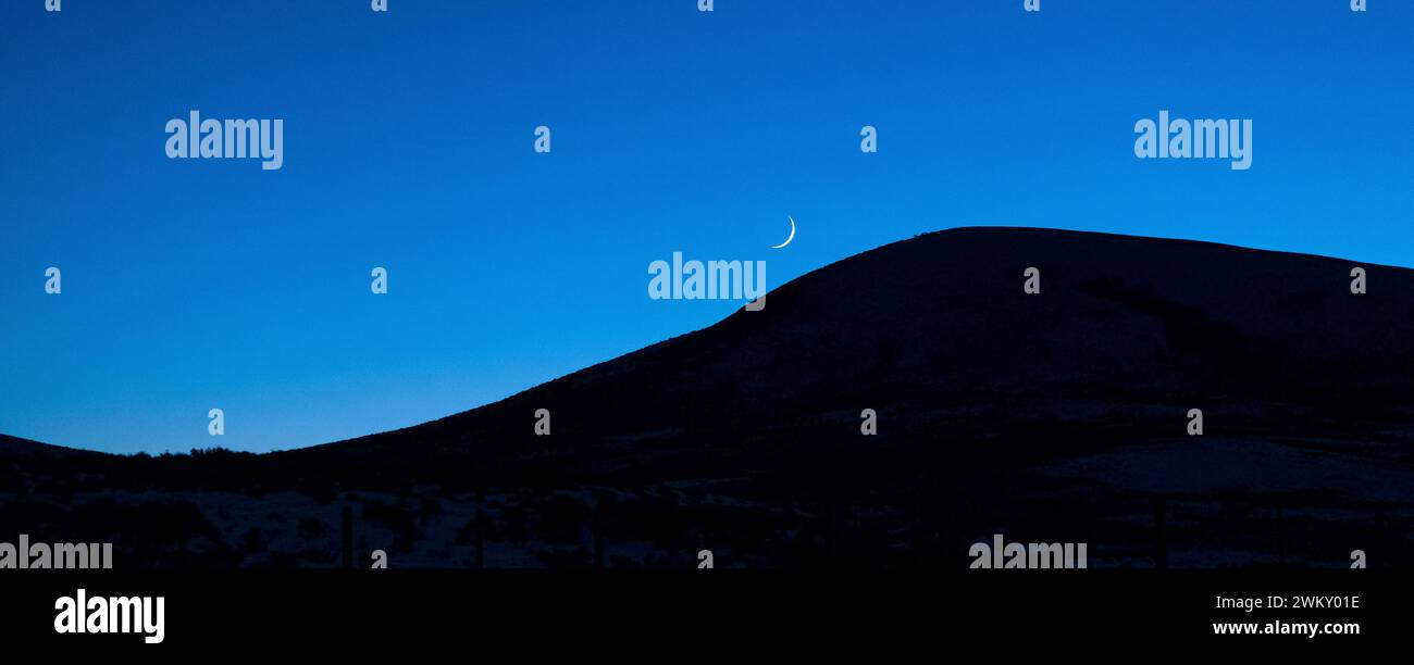 Crescent moon in the sky at dusk, Fossil Butte, Wyoming, USA Stock Photo
