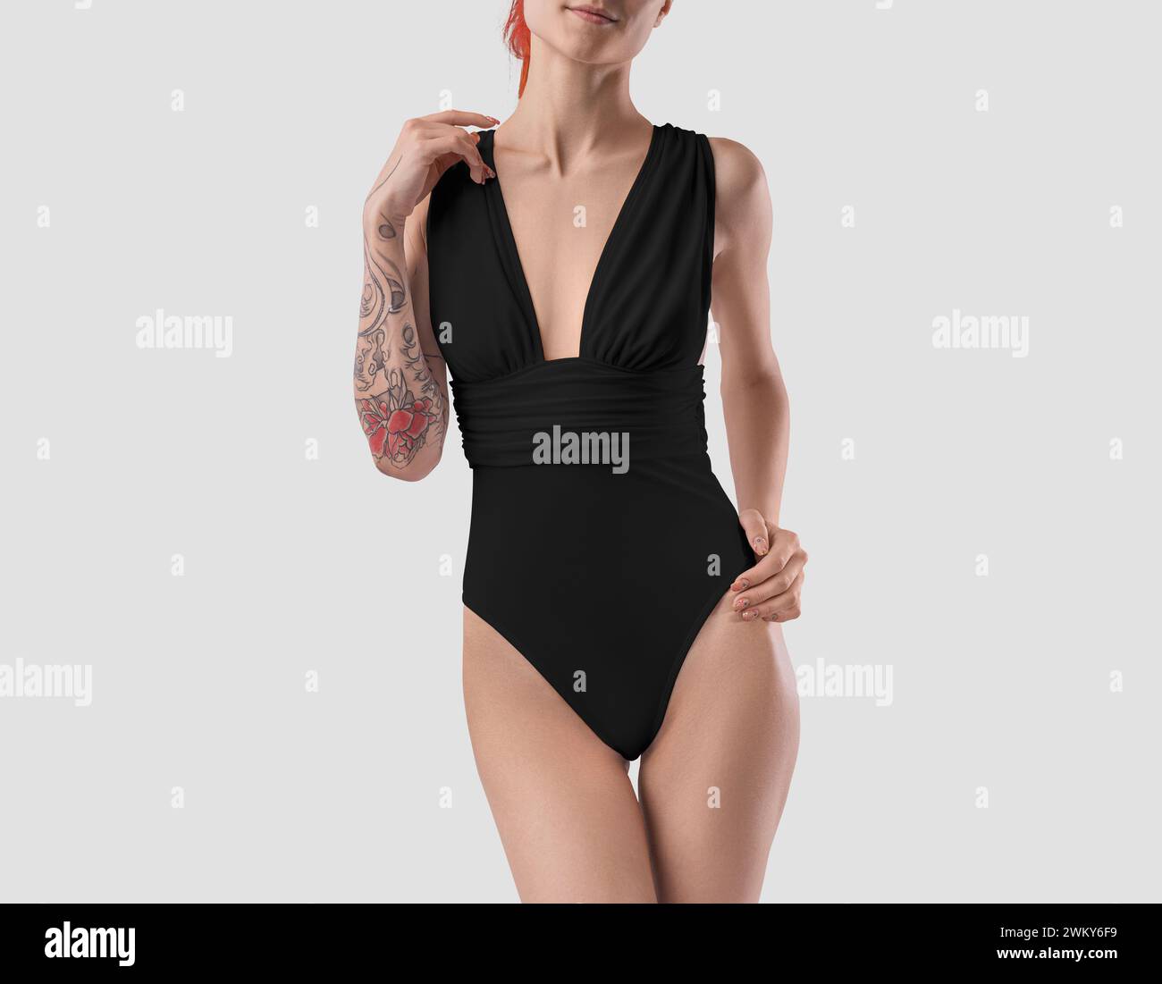 Mockup of a black beach swimsuit on a slender girl with a tattoo, front view. Luxury swimsuit with neckline. Trendy monokini template for design, bran Stock Photo