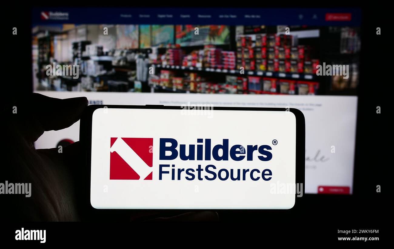 Person holding smartphone with logo of US building materials 