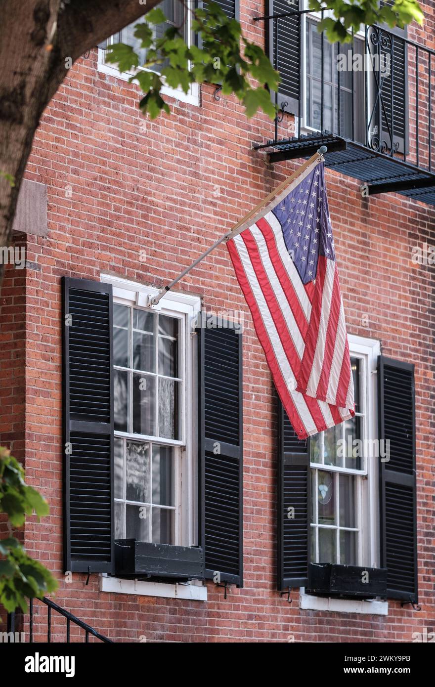 A US Flag Hanging Outside A Traditional Brownstone Townhouse In The Beacon Hill Area Of Boston Stock Photo