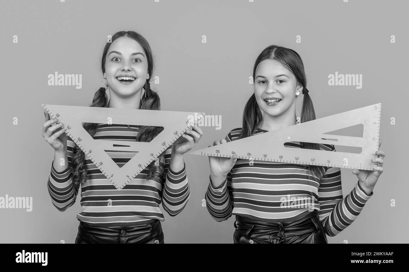 happy school kids hold math tool of triangle Stock Photo - Alamy