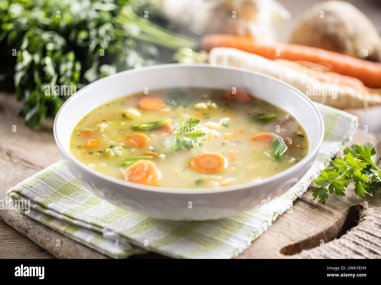 Spring vegetable soup with chopped and grated root vegetables, seasoned with yeast. Healthy vegetable vegetarian food. Stock Photo