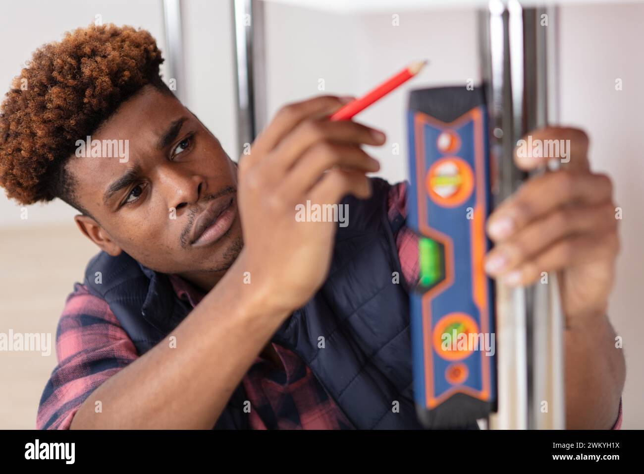 young handsome builder using spirit level equipment Stock Photo