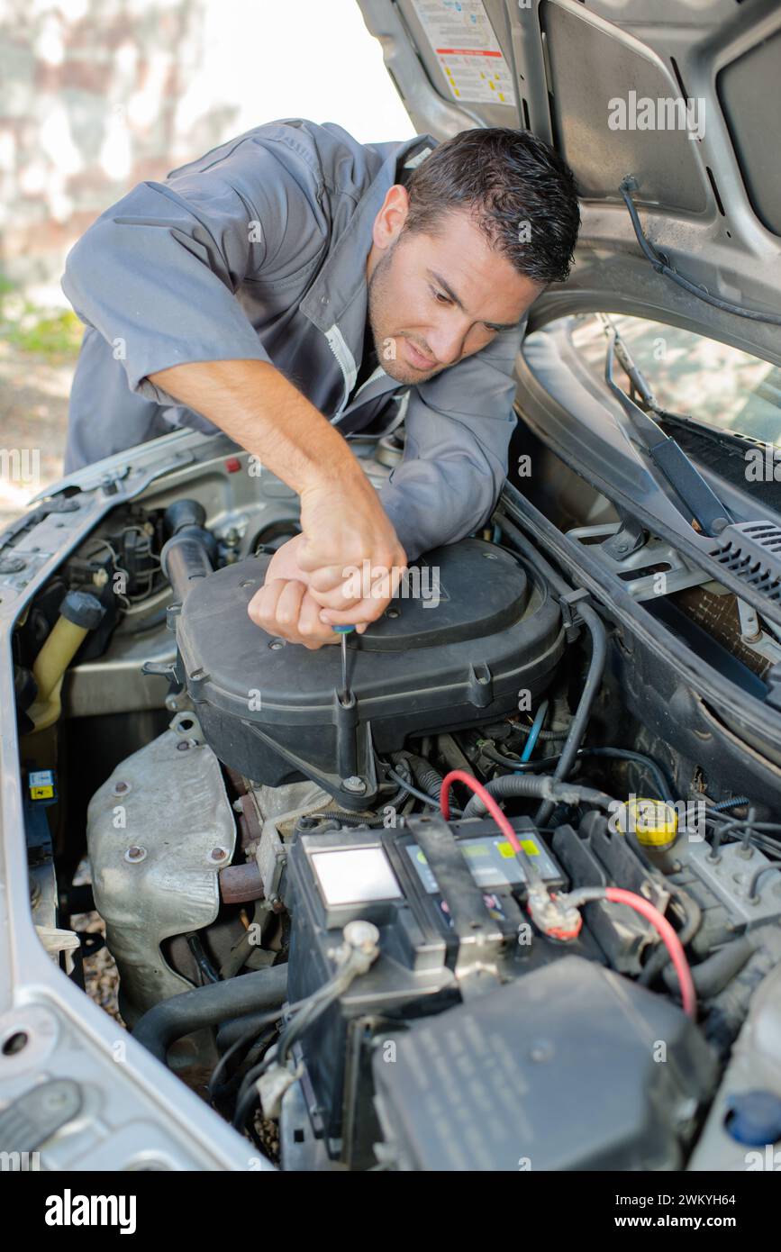 a mechanic is fixing car Stock Photo - Alamy