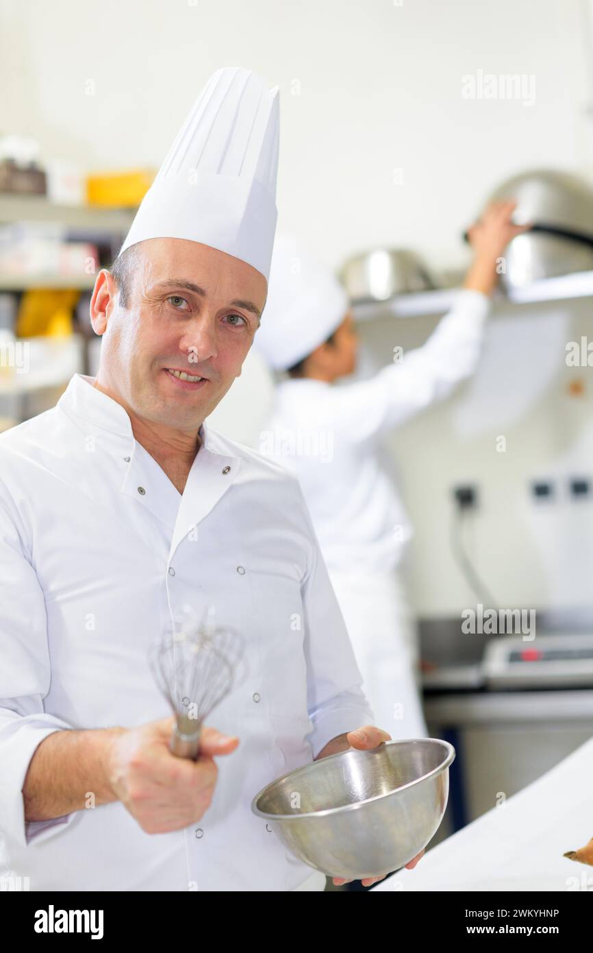 portrait of professional male chef holding bowl and whisk Stock Photo ...