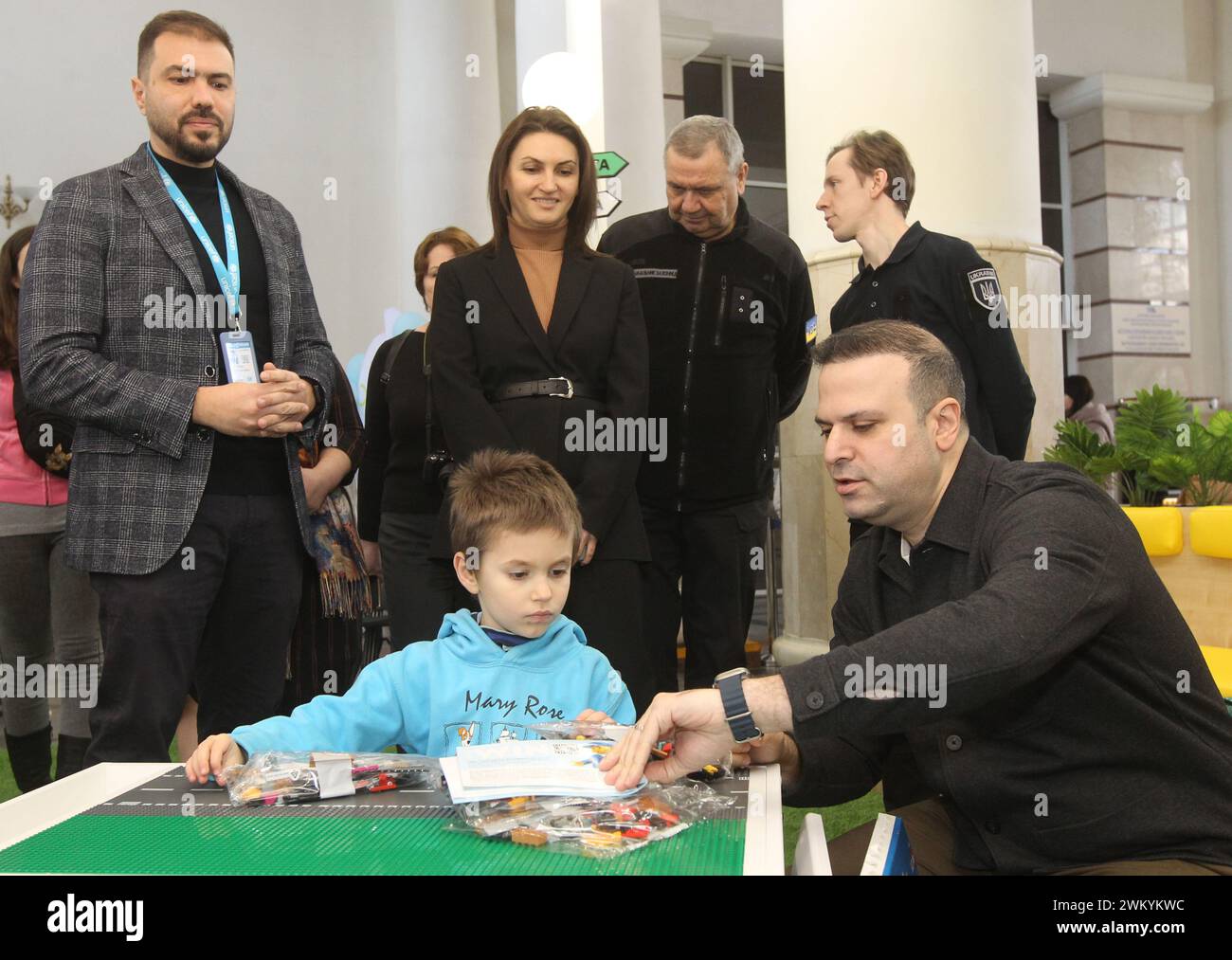 Non Exclusive: DNIPRO, UKRAINE - FEBRUARY 19, 2024 - Grown-ups are pictired next to a boy at the "Spilno" safe space at the Central Railway Station, D Stock Photo