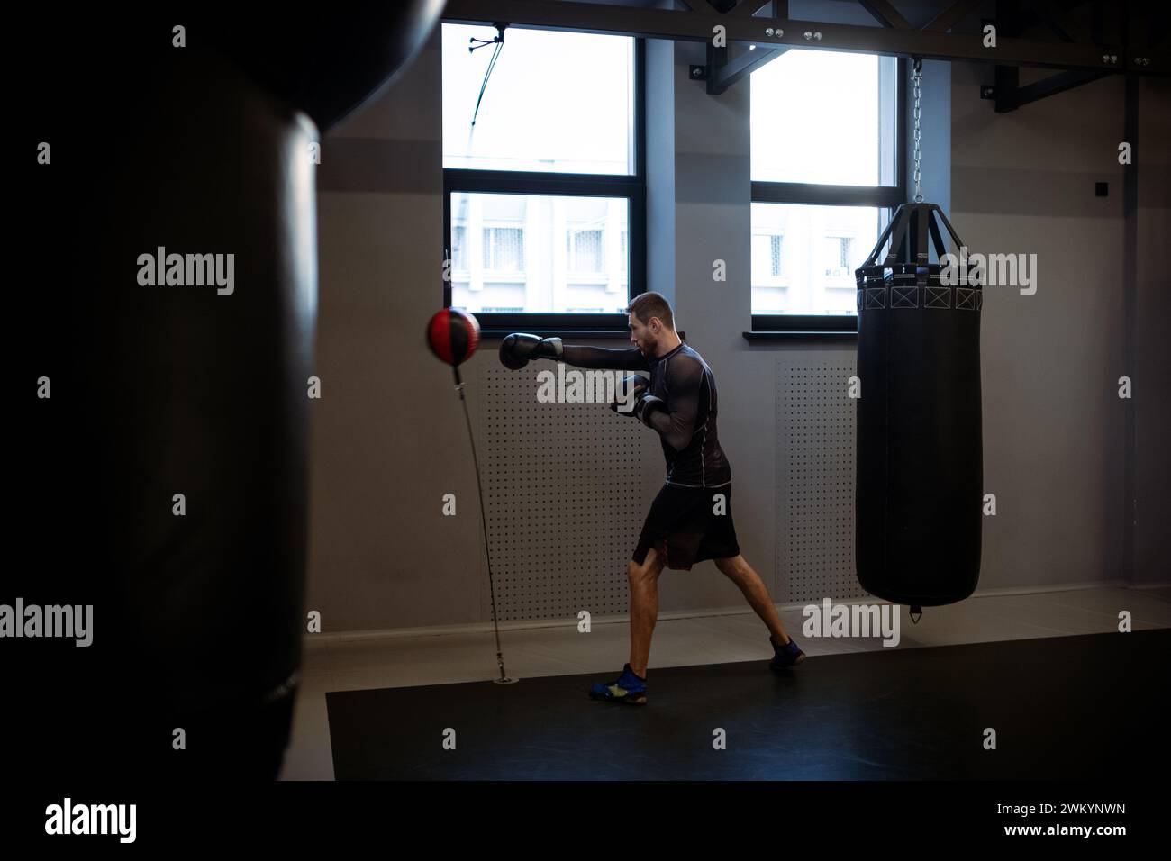 Focused athlete in boxing gym working on punching technique and speed