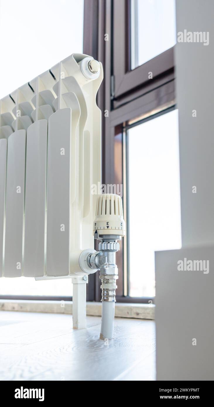 White big radiator near window in modern room Stock Photo - Alamy