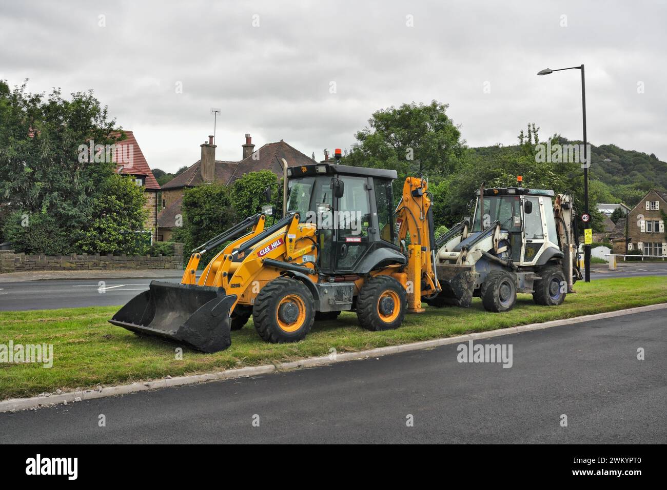 JCB's machinery diggers parked on a grass verge in Abbey lane Beauchief Sheffield UK Stock Photo