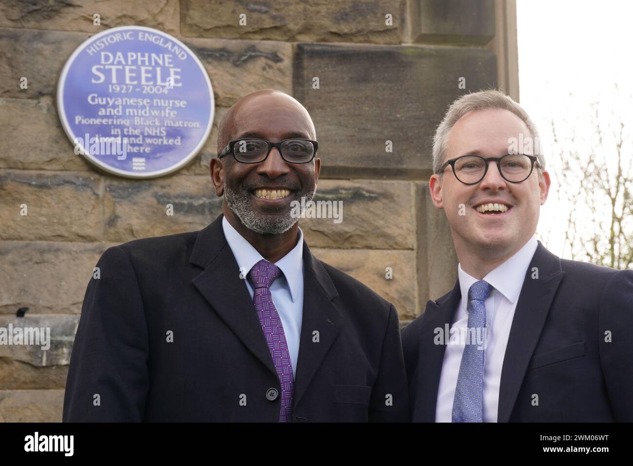 Daphne Steele's son Robert (left) with Arts and Heritage Minister Lord Parkinson unveil a blue plaque honouring Daphne Steele, the NHS's first black matron, at the former St Winifred's maternity home in Ilkley, West Yorkshire, the first official blue plaque to be installed outside of London. Picture date: Friday February 23, 2024. Stock Photo