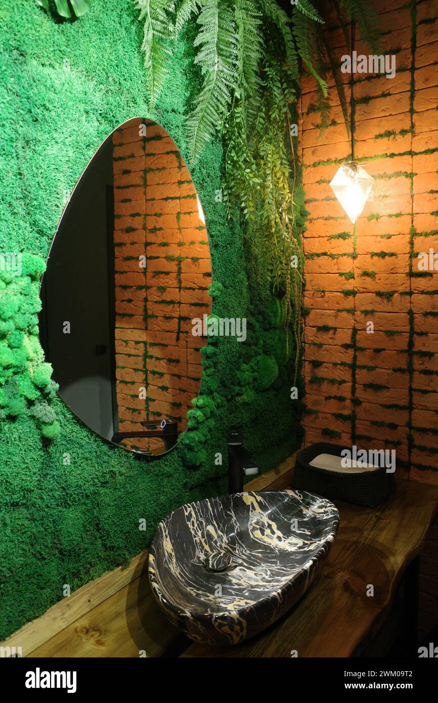 The bathroom is tropical style. Jungle and loft. A combination of red brick and greenery Stock Photo