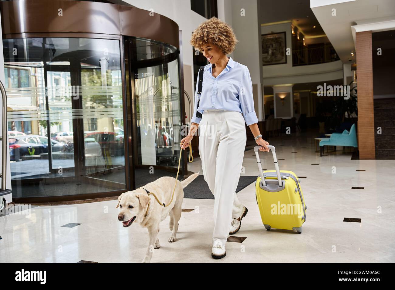happy traveler with her Labrador in a petfriendly hotel entrance