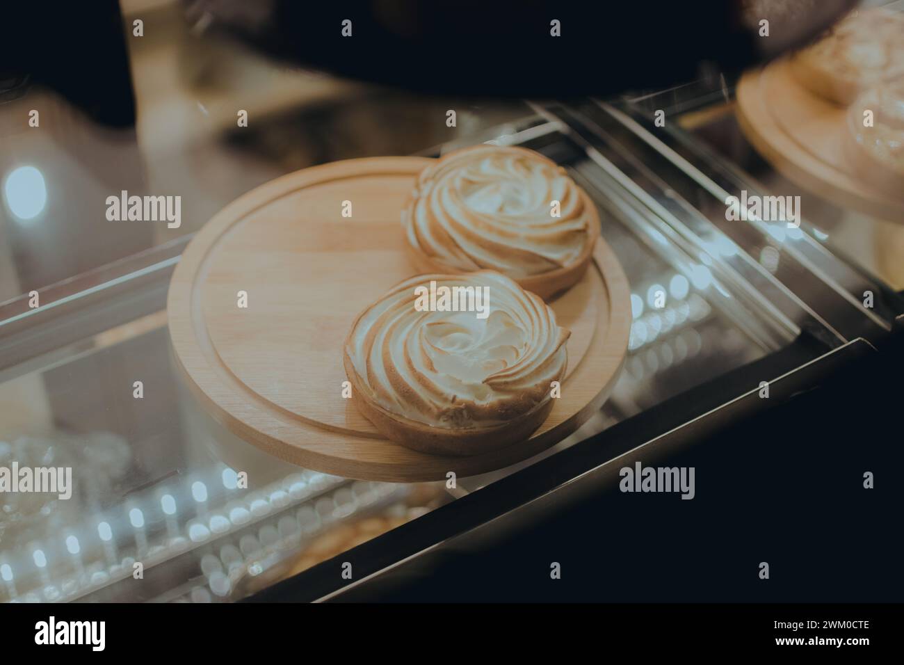Three pastries in glass display case on metal counter Stock Photo