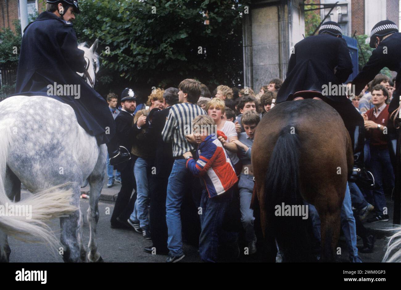 Chelsea Stamford Bridge football ground 1980s UK. Arsenal young football fans after a game (Chelsea v Arsenal) Police crowd control on horseback. London, England 1985. England HOMER SYKES Stock Photo