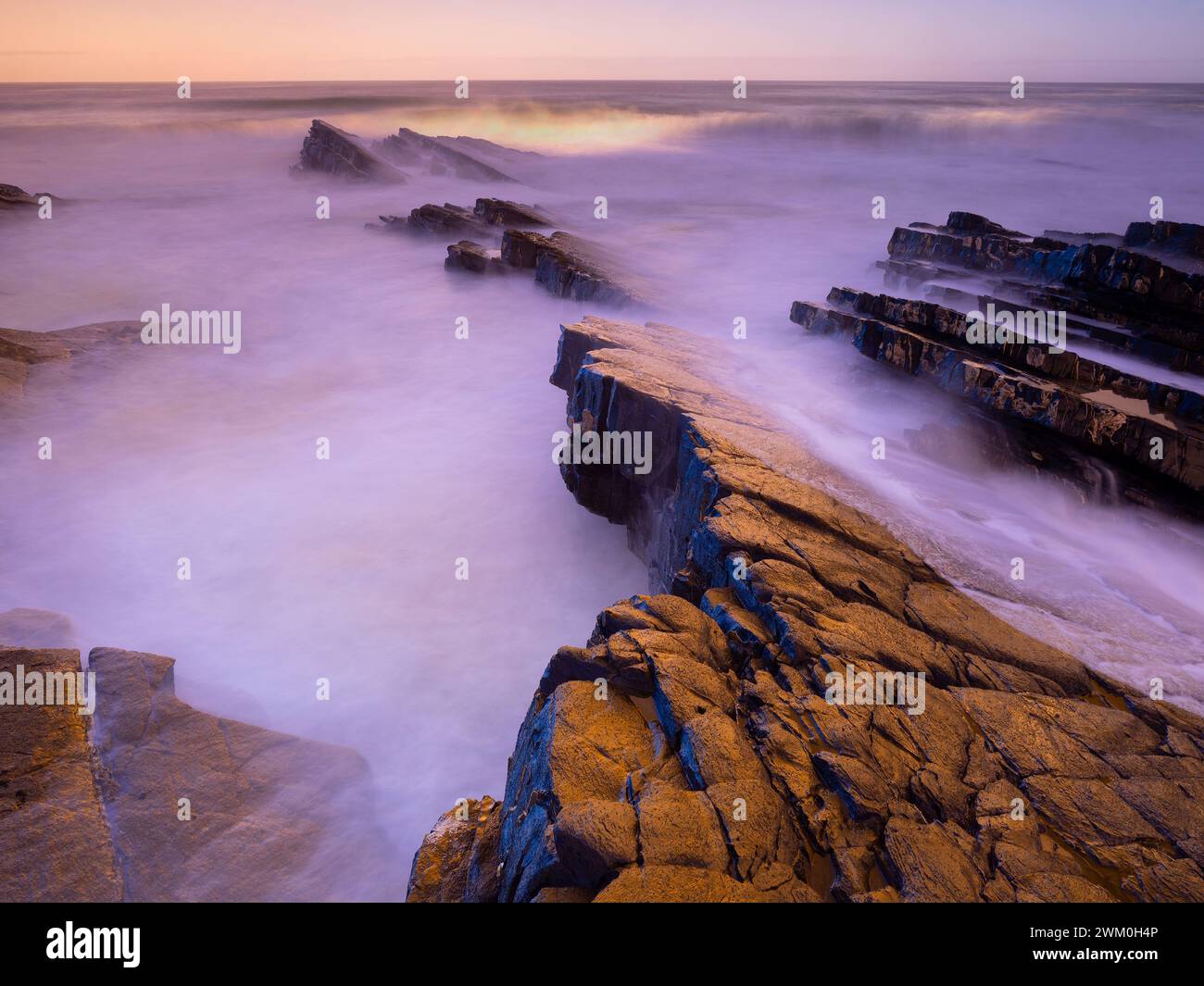 Portugal, Alentejo, Zambujeira do Mar, Long exposure of rocky beach at dusk Stock Photo