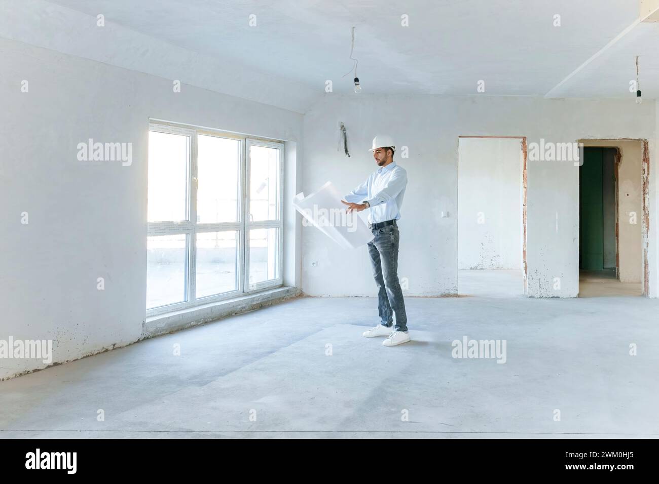 Architect examining blueprint at construction site Stock Photo