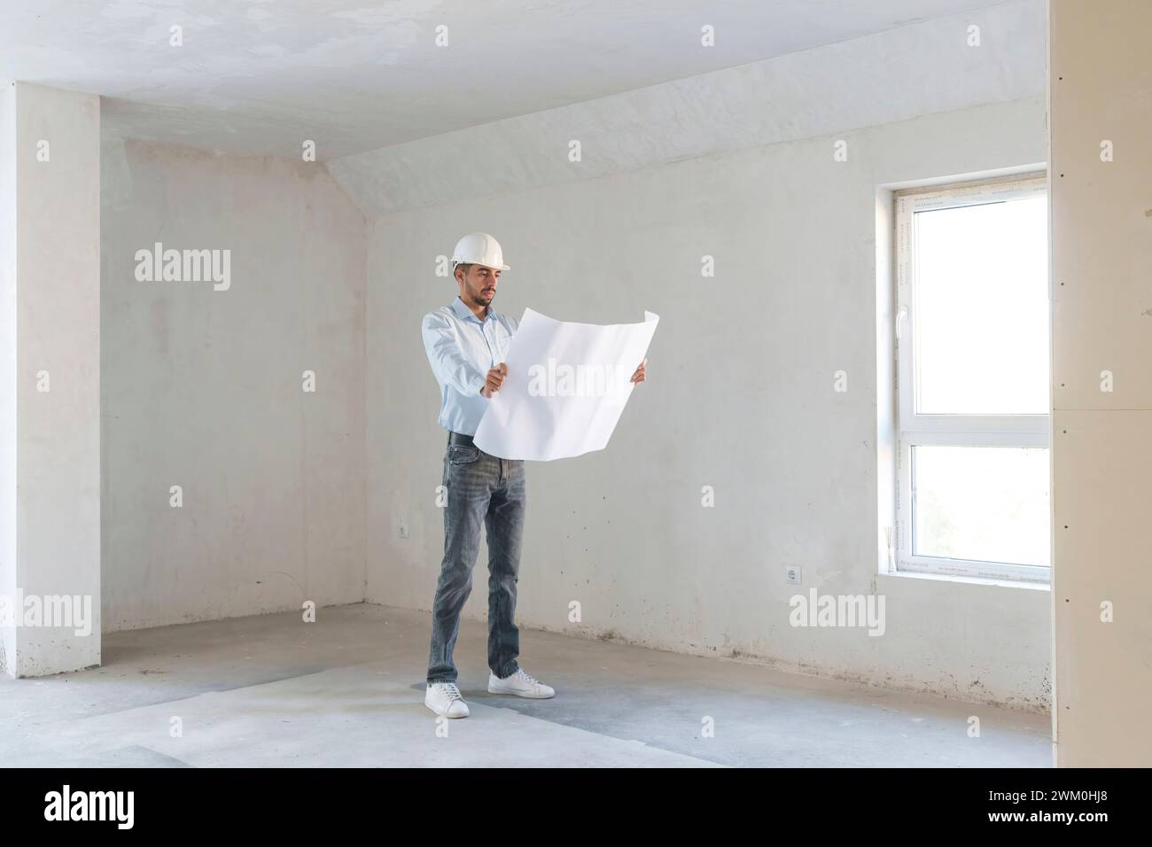 Architect examining blueprint at construction site Stock Photo
