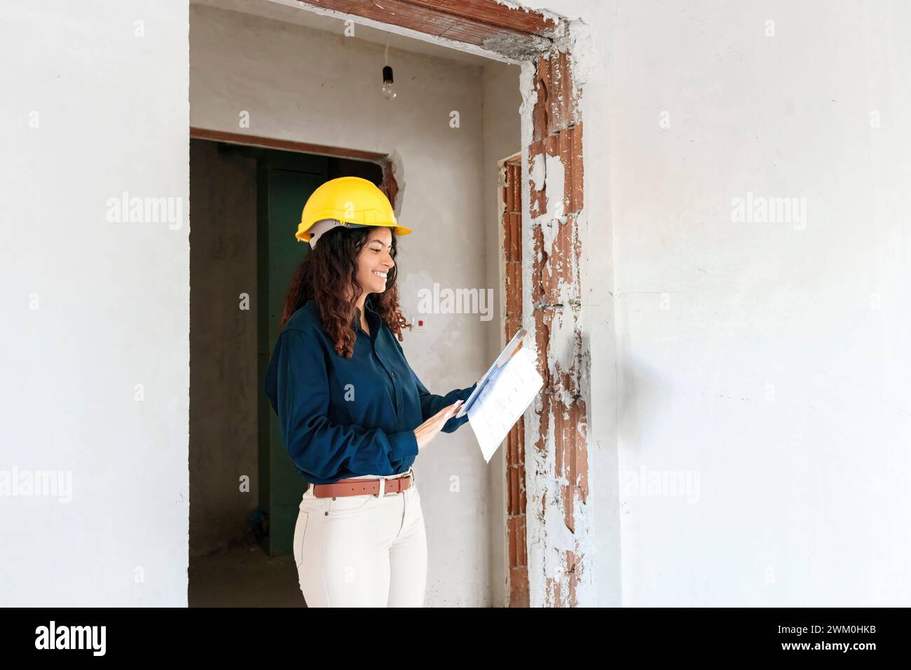 Happy young architect using tablet PC at site Stock Photo