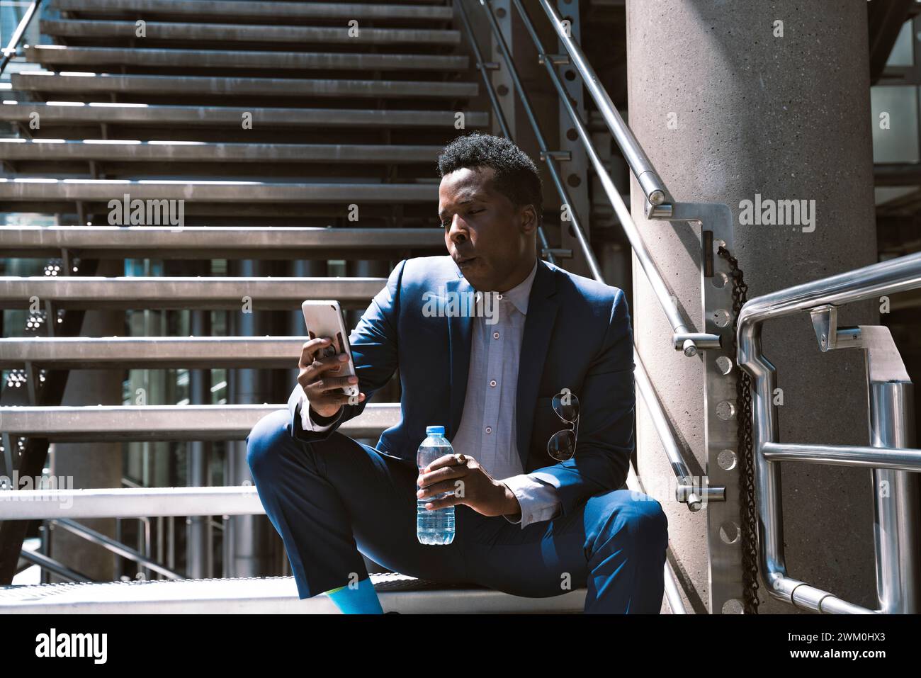 Mature businessman using mobile phone on steps Stock Photo