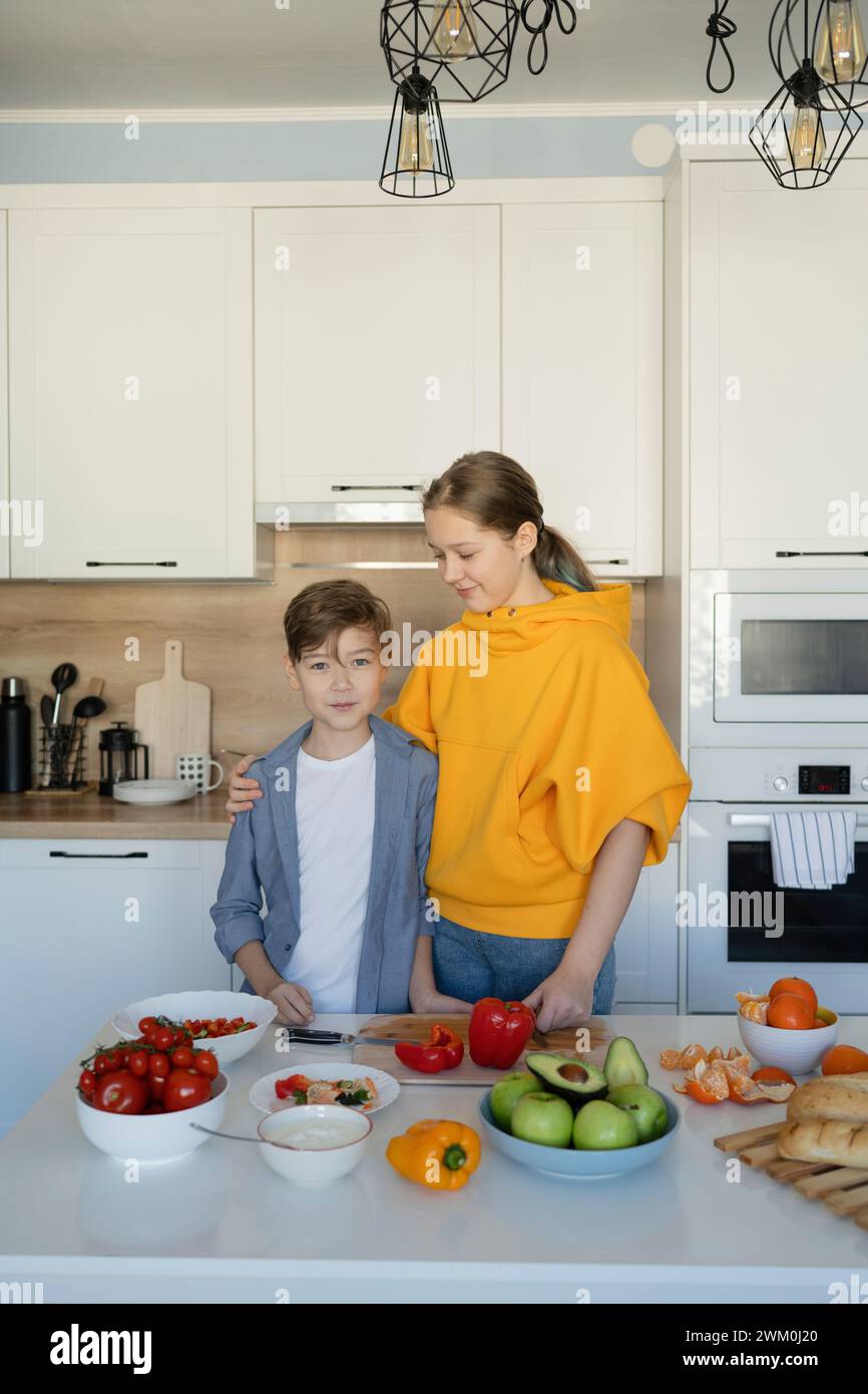 Siblings standing near kitchen island at home Stock Photo