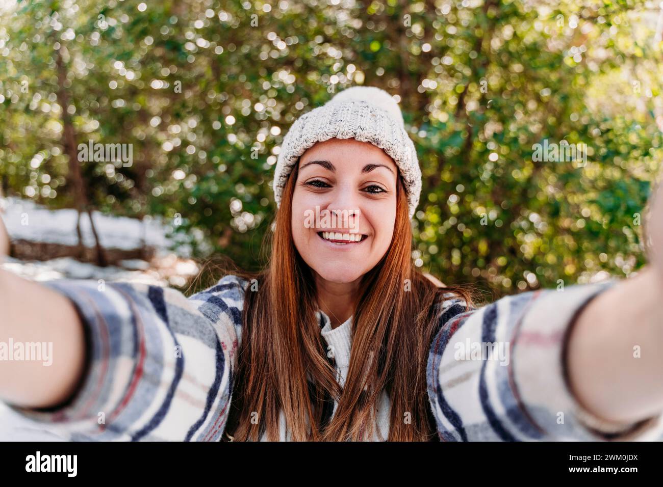 Happy woman wearing knit hat and taking selfie Stock Photo
