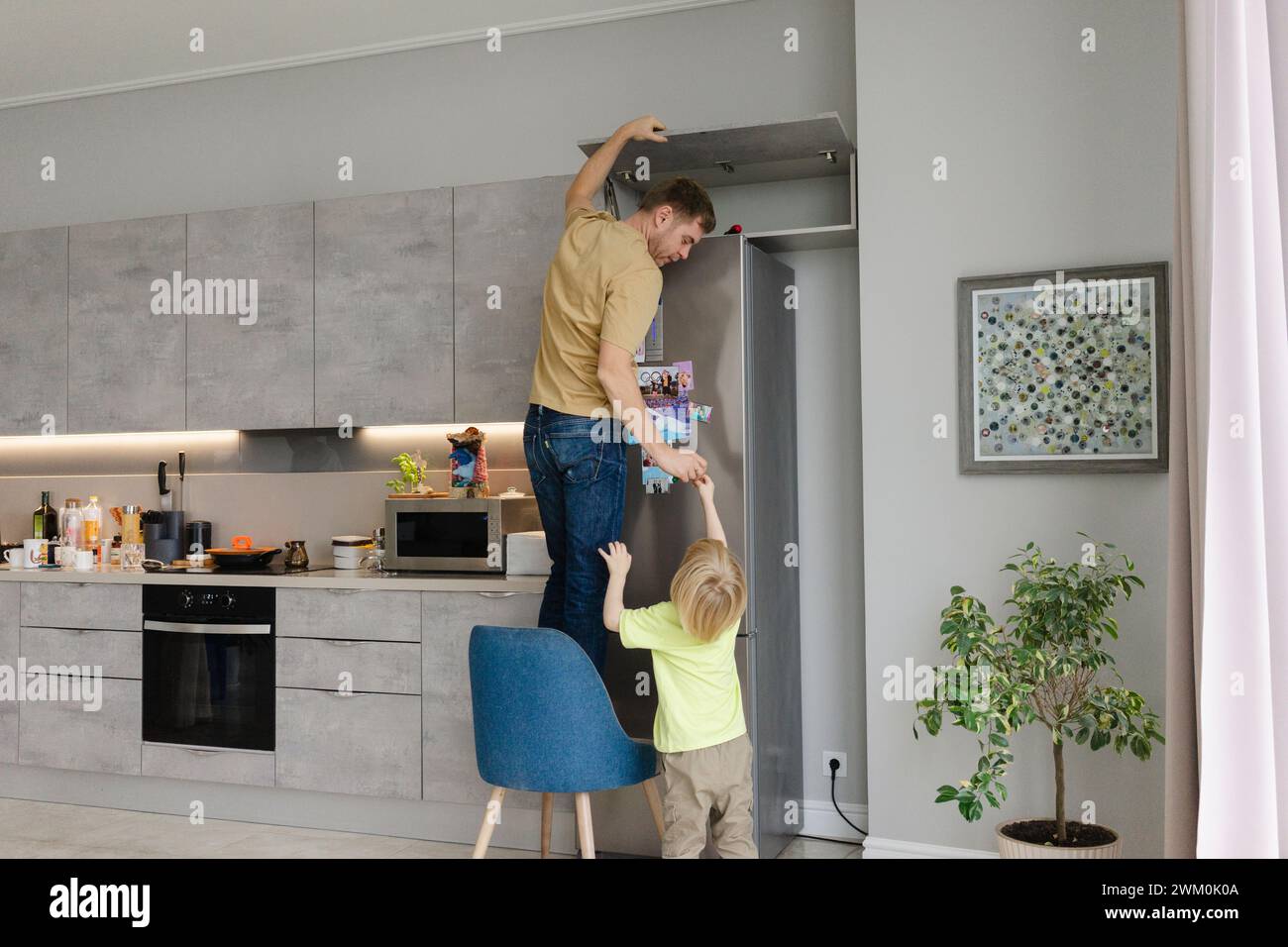 Boy helping father in fixing cabinet at home Stock Photo - Alamy