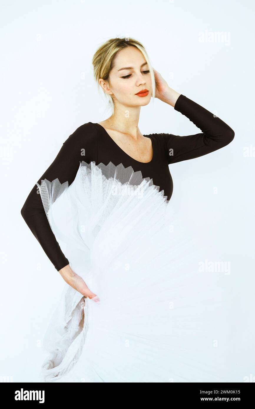 Elegant ballet dancer with white tutu standing in studio Stock Photo