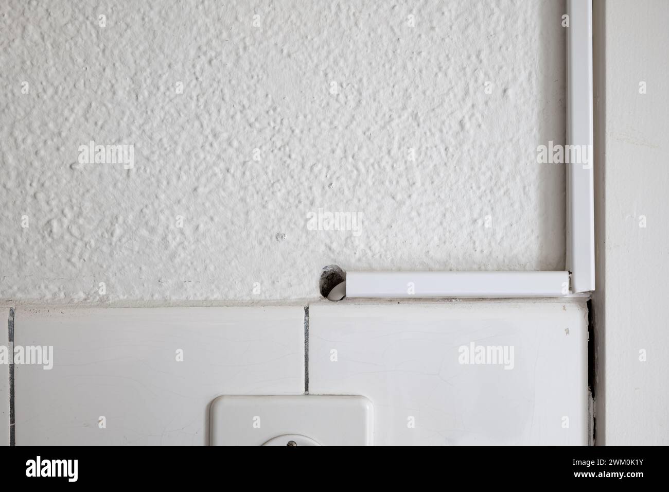 White plastic electric cable duct covers on a kitchen wall. Close up
