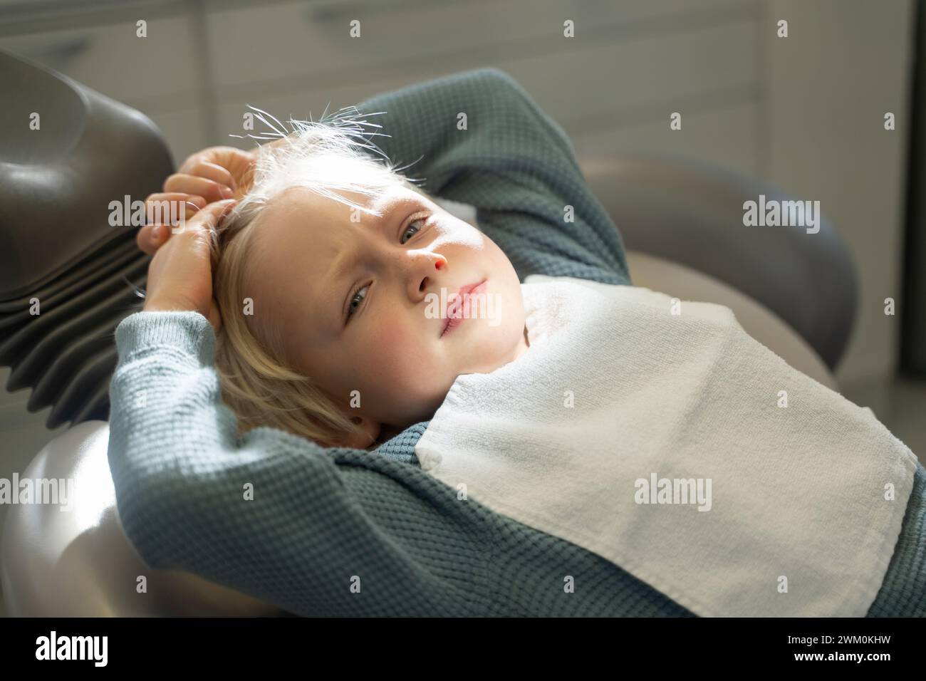 Boy lying on chair to get dental treatment in clinic Stock Photo