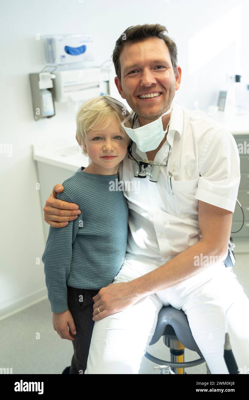 Smiling dentist with boy in clinic Stock Photo