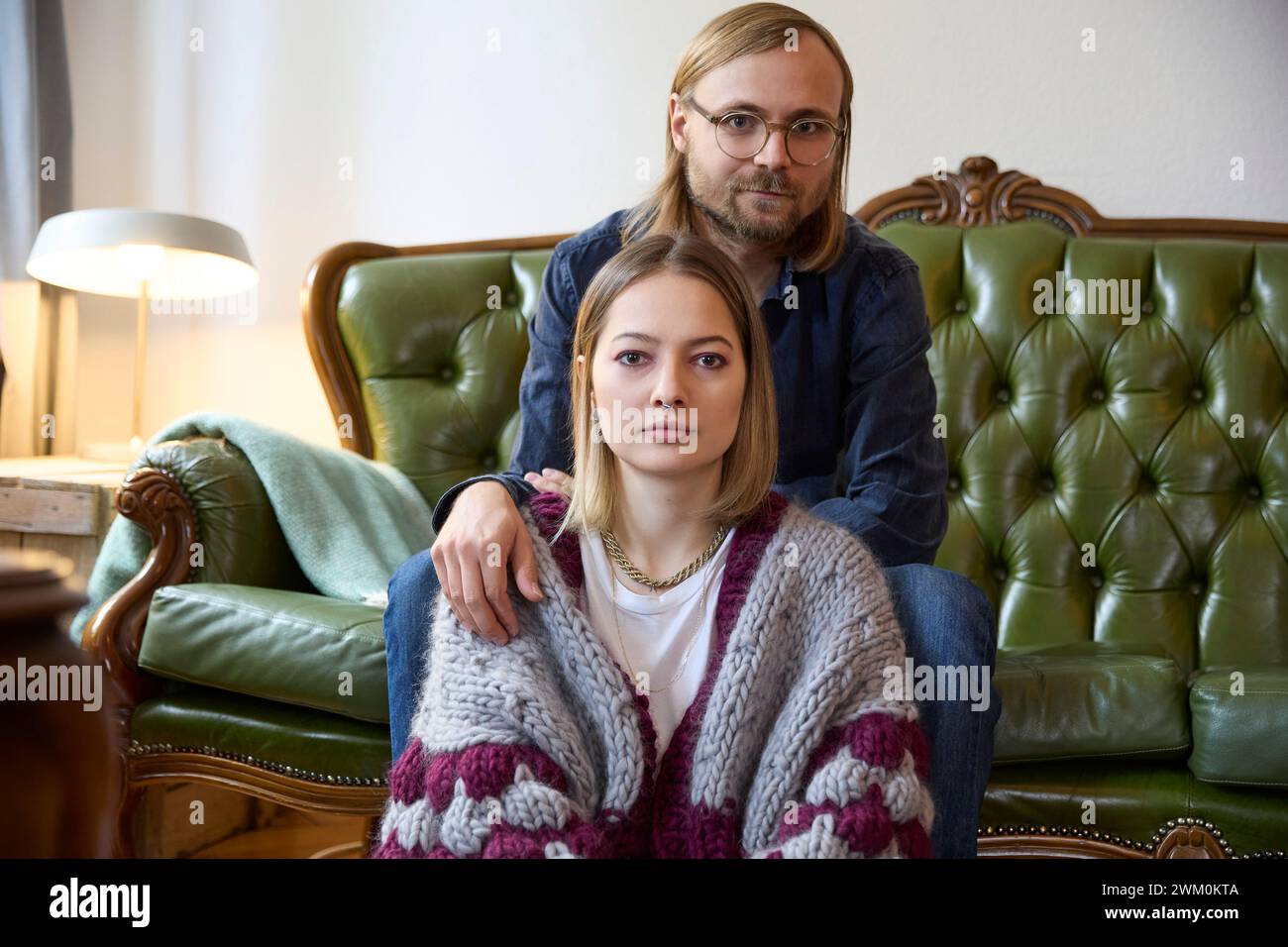 Woman with man sitting on sofa at home Stock Photo