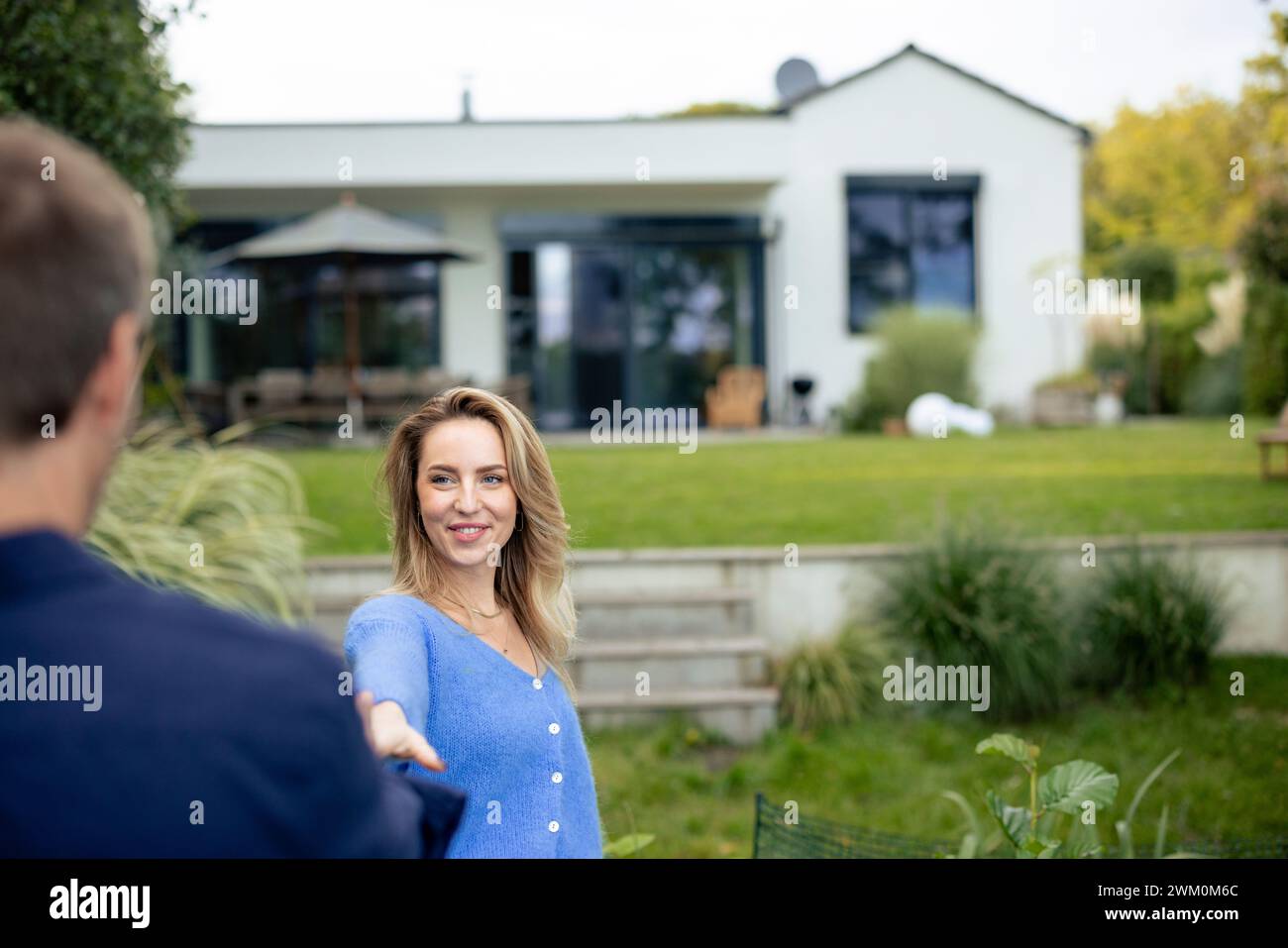 Happy woman enjoying with man in front of house Stock Photo
