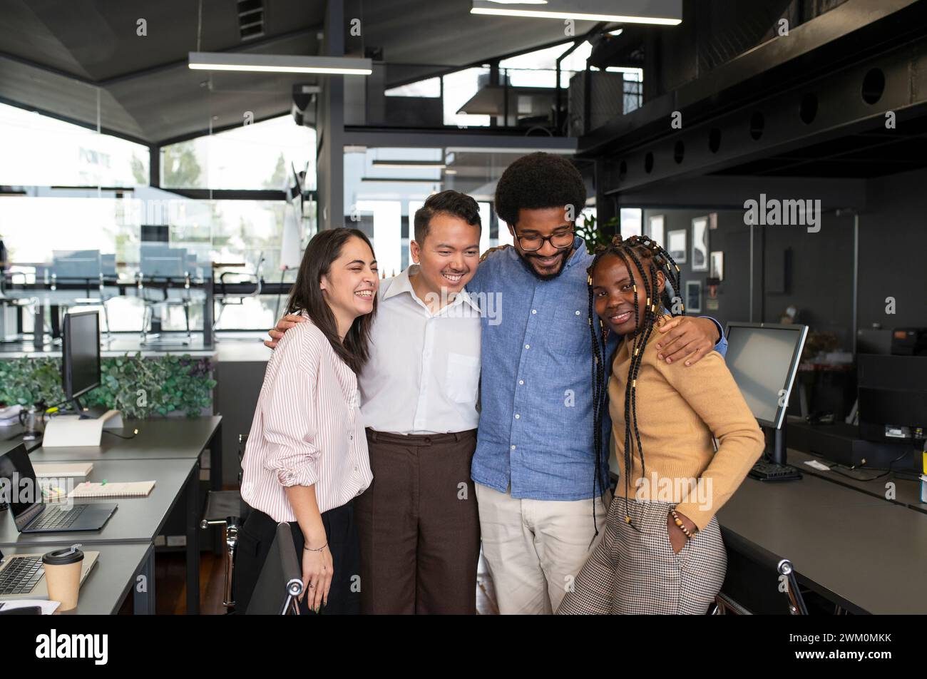 Happy business people standing together in office Stock Photo - Alamy